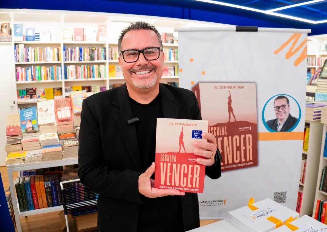 Julio Amorim, fundador da Great Group, segurando o livro Escolha Vencer